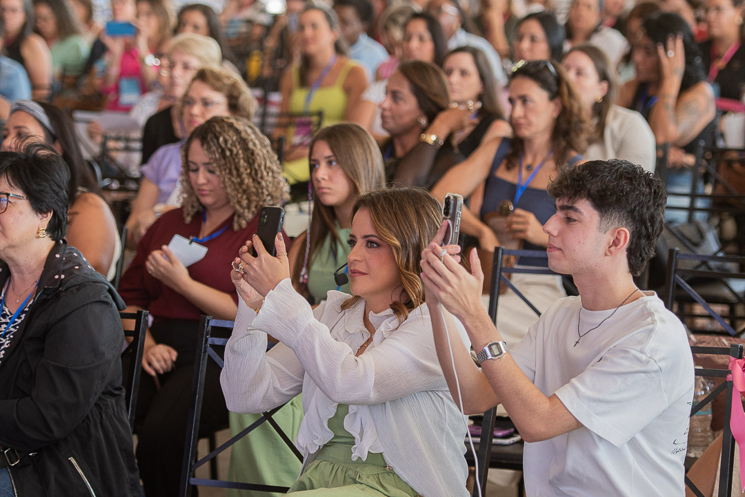 Participantes registrando o conteúdo no auditório lotado
